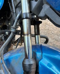 A close-up photo of a front shock absorber in a motorcycle, highlighting its sleek metallic design and mechanical structure. Ideal for themes of mechanics, engineering, and automobile parts.