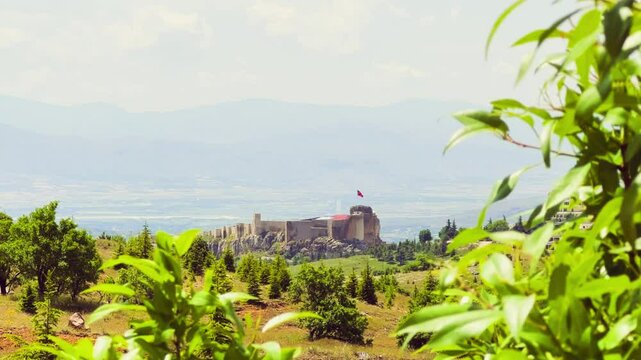 Harput fortress with the Turkish flag, in the spring in Eastern Anatolia, Elazig, Turkey. Harput Castle or Harberd, also known as Sut Kalesi. Ancient city. 4К