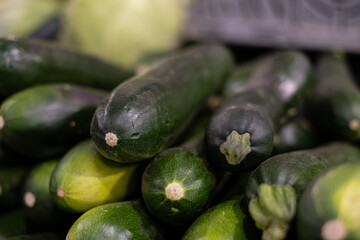 In the fruit and vegetable market view of some freshly picked zucchini, concept of healthy eating with zero-mile products