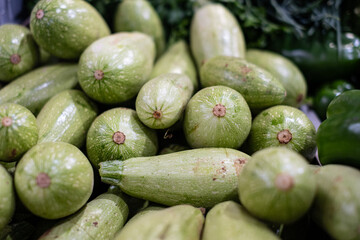 In the fruit and vegetable market view of some freshly picked zucchini, concept of healthy eating with zero-mile products