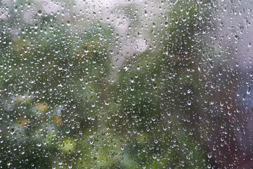 Transparent blurred window on the background of nature with raindrops. With copy space. High quality photo