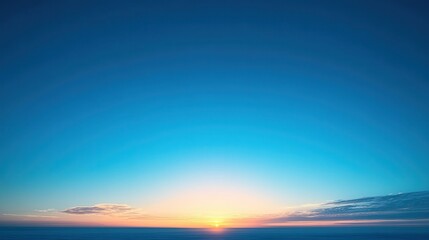Fototapeta premium Expansive blue sky at sunrise with golden light