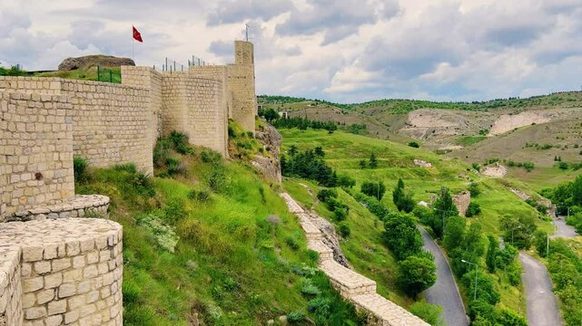 Harput fortress with the Turkish flag, in the spring in Eastern Anatolia, Elazig, Turkey. Harput Castle or Harberd, also known as Sut Kalesi. Ancient city. 4К
