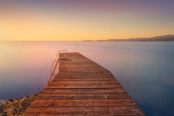 Obraz premium Wooden pier on Lake Trasimeno. Long exposure photography. Magione, Umbria, Italy