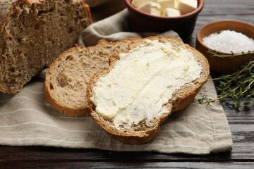 Fresh bread with butter on wooden table, closeup