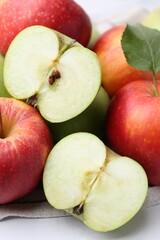 Different ripe whole and cut apples on table, closeup