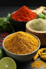 Different aromatic spices, lime and herbs on black background, closeup