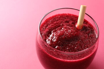 Fresh beetroot smoothie in glass on pink background, closeup. Space for text