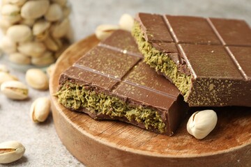 Pieces of Dubai chocolate bar with pistachios and knafeh on grey table, closeup