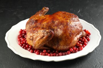 Delicious baked turkey and cranberries on dark gray textured table, closeup