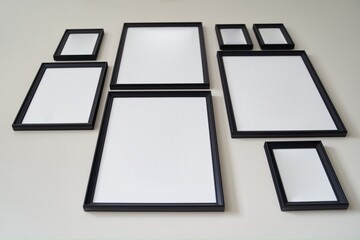 Fototapeta premium Different size framed photos hanging on the gray wall. High quality photo