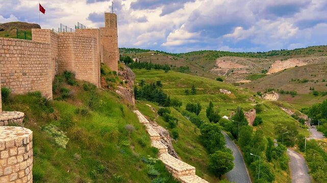 Harput fortress with the Turkish flag, in the spring in Eastern Anatolia, Elazig, Turkey. Harput Castle or Harberd, also known as Sut Kalesi. Ancient city. 4К