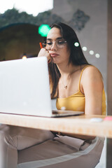 Bored woman working on laptop in cafe