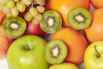 A vibrant assortment of kiwi, apples, oranges, and grapes in close-up