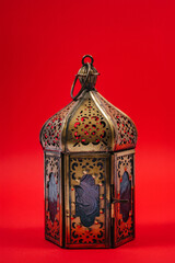 An oriental-style iron candlestick on a red background. metal candelabrum for lighting candles