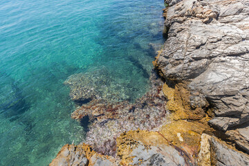 Crystal Clear Waters and Rocky Shoreline in Greece on a Sunny Summer Day