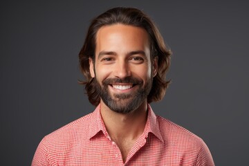 Obraz premium smiling man with long hair and beard wearing a red and white checkered shirt