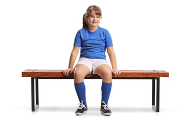 Obraz premium Girl in football sportswear sitting on a bench