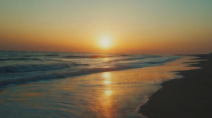 Golden sunset over serene beach with gentle waves and vibrant sky hues of orange and pink