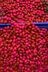 A close-up photograph of a large quantity of cornelian cherry flavored olive