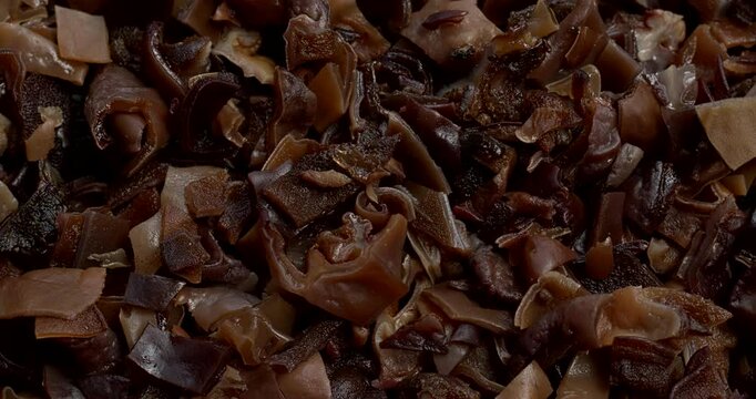 Dried, hydrated and chopped mun mushrooms as an abstract food pattern. An ingredient of Chinese cuisine. Table spin.