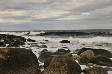 Stormy weather, Waves crashing on a rocky beach.