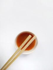 bamboo chopsticks on a bowl of chili sauce