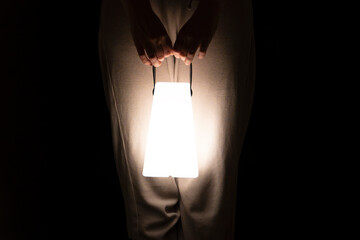 woman hands holding big electric lantern at night, electricity deficiency concept, blackout, energy safe hand torch © Nestudio