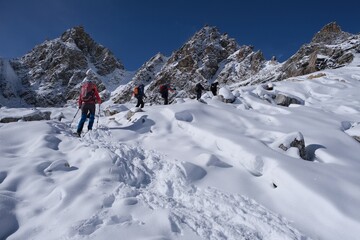 Winter mountain panorama with climbing trekkers during route to Renjo La Pass. Sagarmatha National Park, Himalayas, Nepal