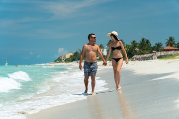 couple sitting on sand by turquoise ocean, trip to cuba, honeymoon	