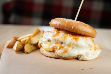 close-up of juicy hamburger with fried egg and potatoes on the table. Takeaway