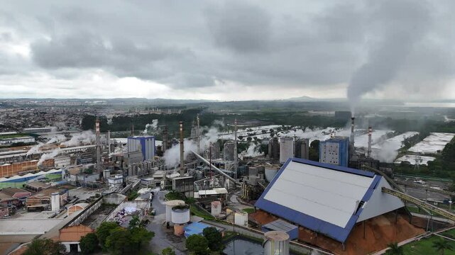Vis&atilde;o a&eacute;rea de uma grande ind&uacute;stria de papel e celulose, destacando o processo de produ&ccedil;&atilde;o, maquin&aacute;rio e infraestrutura, com foco na sustentabilidade e efici&ecirc;ncia da opera&ccedil;&atilde;o