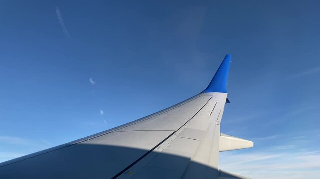 Smooth Turn of Airplane Wing Against Clear Blue Sky