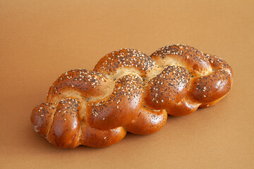 Bread loaf with seeds on warm brown background close up