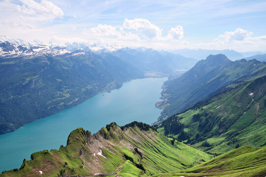 Breathtaking panoramic view of Lake Brienz, surrounded by lush mountains and snow-capped peaks in Switzerland. Perfect for nature lovers and adventure seekers.