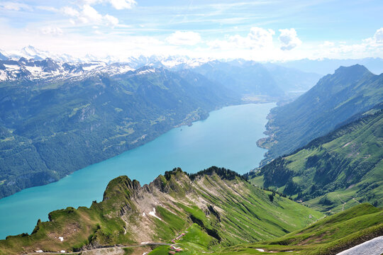 Breathtaking view of Lake Brienz surrounded by lush green mountains and snow-capped peaks in Switzerland. Perfect for nature lovers and adventure seekers.