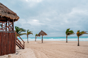 Rustic Beach Scene with Thatched Hut and Swaying Palms