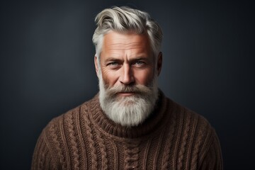 Obraz premium A portrait of a mature man with a stylish gray beard, dressed in a cozy sweater, exuding confidence and wisdom.