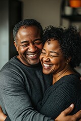 Obraz premium Couple hugging and laughing in the home kitchen with love, getting closer and smiling together with joy.