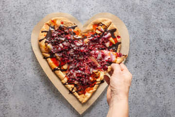 Food for Valentine's Day. Heart shaped sweet pizza with pineapple on gray background. View from above. Romantic dinner.