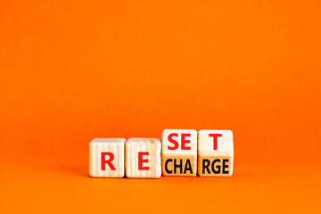 Reset and recharge symbol. Concept words Reset Recharge on beautiful wooden block. Beautiful orange table orange background. Business reset and recharge concept. Copy space.