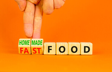 Fast or homemade food symbol. Concept words Fastfood or Homemade food on wooden cubes. Beautiful orange table orange background. Doctor hand Healthy lifestyle Fast or homemade food concept. Copy space