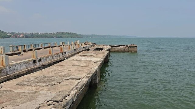 The Dona Paula viewpoint A concrete pier extending into the water, likely part of an old or functional dock.