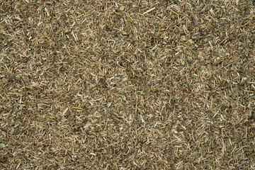 Close-up of scattered dried thyme leaves covering the entire surface, creating a textured pattern....
