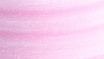 Close up of pink cotton candy, showcasing its fluffy, spun sugar texture.  Sweet treat, carnival, fair, dessert concept.