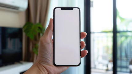 hand holding mobile phone with empty screen in front of air conditioning unit