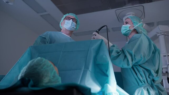 Medical team performing a possible C-section surgery in an operating room, with focus on surgeons in sterile attire. Concept of professional healthcare, childbirth, and teamwork in modern surgery