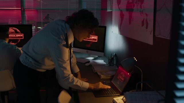 Medium side shot of Caucasian female army officer in uniform frantically typing commands on computer and shouting to male colleague during IT systems breakdown or hacker attack at operations center