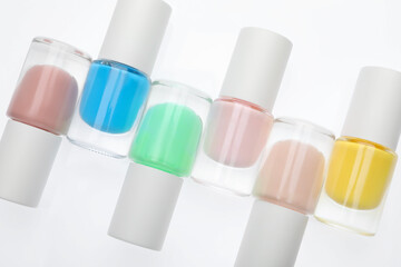 Nail polishes in bottles on white background, top view