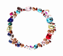 Frame of different shiny gemstones on white background, flat lay. Space for text